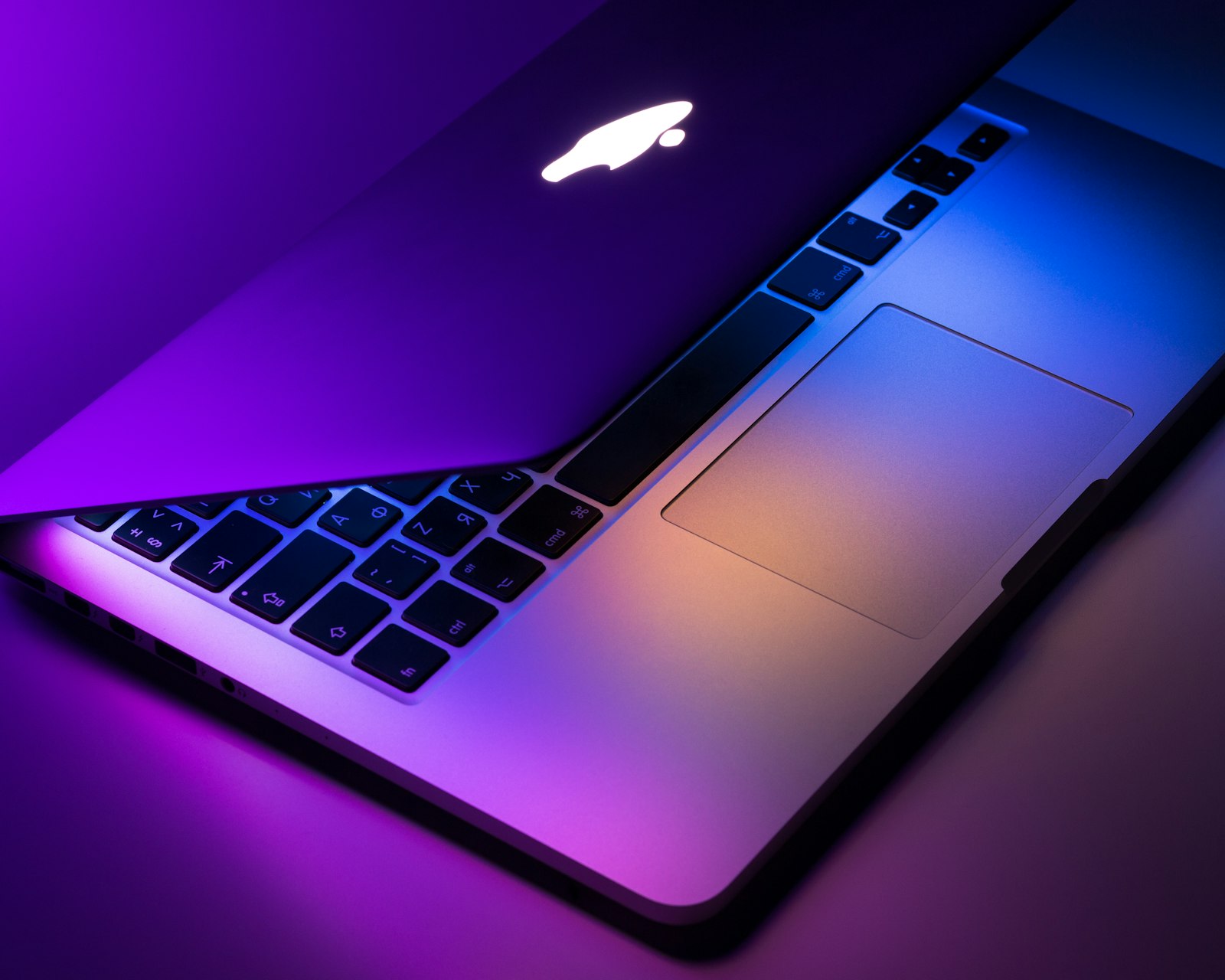 Laptop con el logo iluminado en tonos morados